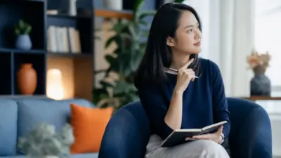 Guru dan siswa sekolah dasar duduk berdampingan membahas penggunaan tablet sebagai bagian dari asesmen psikologi literasi digital anak