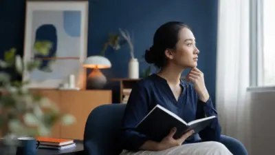 Seorang dewasa duduk dekat jendela menulis jurnal dengan suasana tenang merefleksikan kesehatan mental
